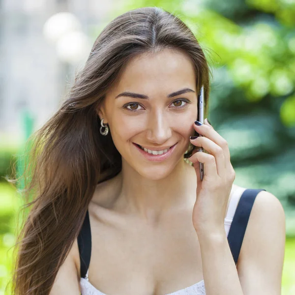 Belle jeune femme brune appelant par téléphone — Photo