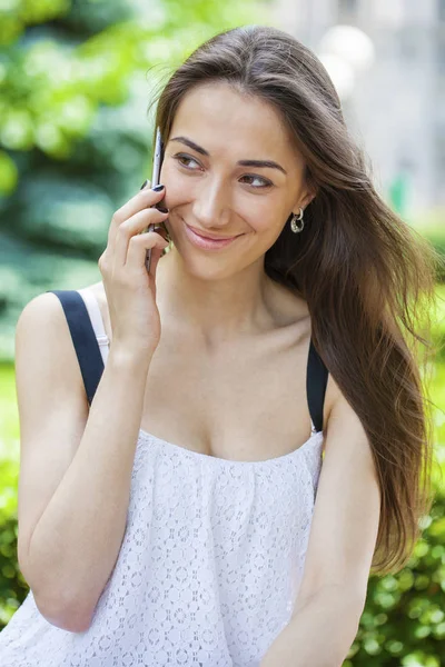 Vacker ung brunett kvinna ringer via telefon — Stockfoto