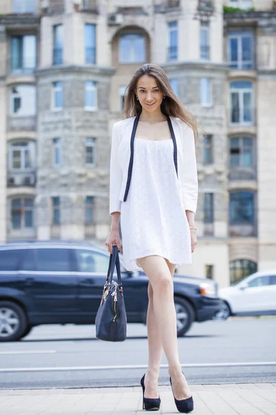 Fiatal gyönyörű barna nő fehér ruhában, séta a str — Stock Fotó