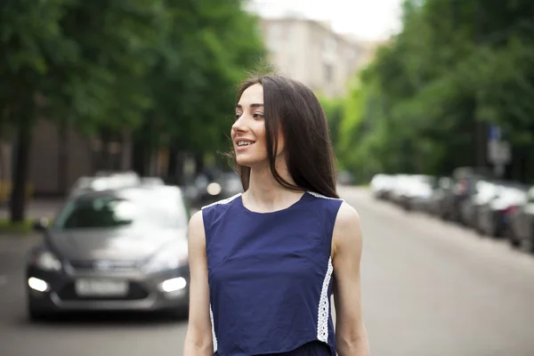 Jeune belle femme dans une robe courte bleue marchant sur la route — Photo