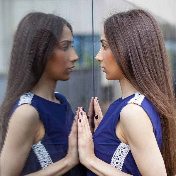 Senhora elegante em vestido azul posando perto de parede espelhada — Fotografia de Stock