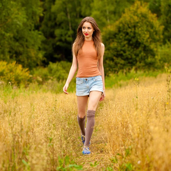 Young beautiful woman walking in a field, summer outdoors — Stock Photo, Image