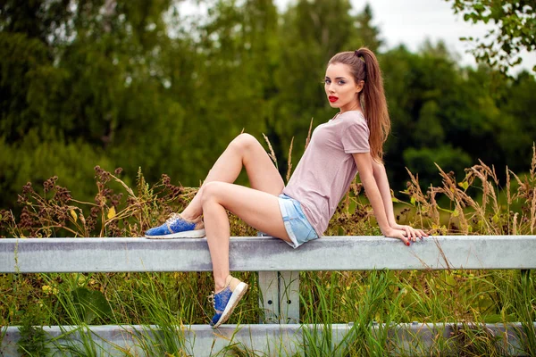 Jovem bela mulher de cabelos castanhos em jeans azuis — Fotografia de Stock