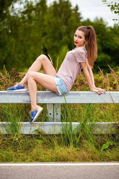 Junge schöne braunhaarige Frau in blauen Jeans — Stockfoto
