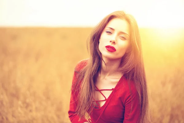 Porträt einer jungen brünetten Frau im roten Kleid — Stockfoto