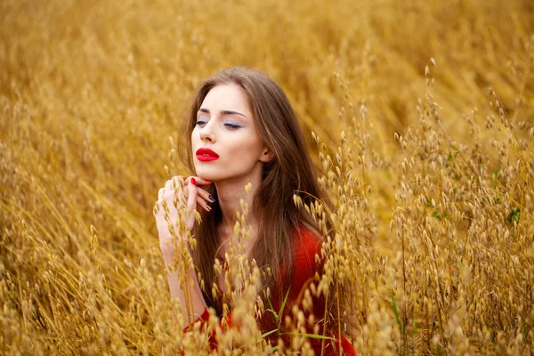 Portrait of a young brunette woman in red dress — Stock Photo, Image