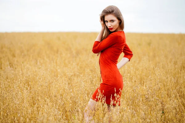 Portret van een jonge brunette vrouw in rode jurk — Stockfoto