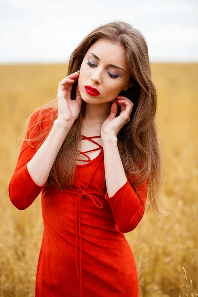 Portret van een jonge brunette vrouw in rode jurk — Stockfoto