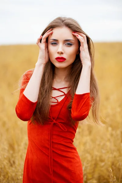 Porträt einer jungen brünetten Frau im roten Kleid — Stockfoto