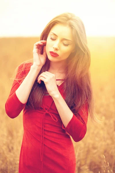 Porträtt av en ung brunett kvinna i röd klänning — Stockfoto