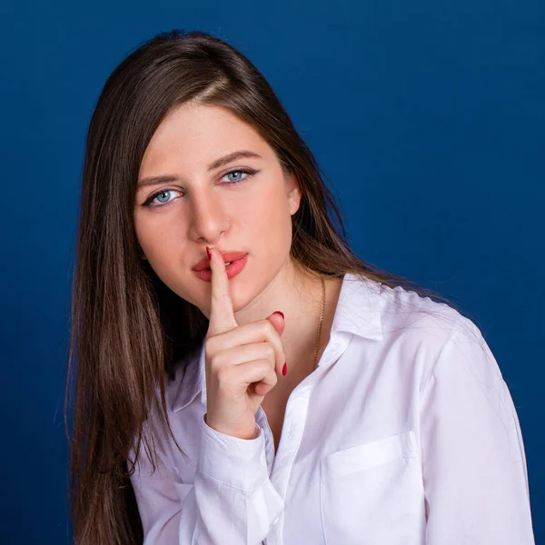 Beautiful brunette woman has put forefinger to lips as sign of s — Stock Photo, Image