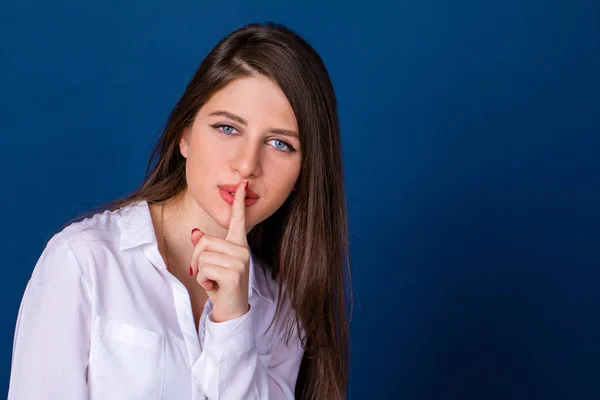 Beautiful brunette woman has put forefinger to lips as sign of s — Stock Photo, Image