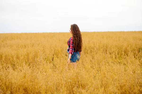 Jovem mulher bonita andando em um campo, verão ao ar livre — Fotografia de Stock