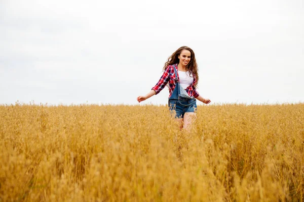 Giovane bella donna che cammina in un campo, estate all'aperto — Foto Stock