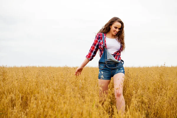 Junge schöne Frau, die in einem Feld spaziert, Sommer im Freien — Stockfoto