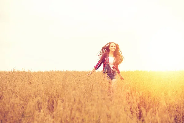 Young beautiful woman walking in a field, summer outdoors — Stock Photo, Image