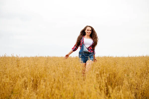 Young beautiful woman walking in a field, summer outdoors — Stock Photo, Image