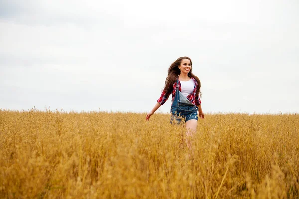 Jovem mulher bonita andando em um campo, verão ao ar livre — Fotografia de Stock