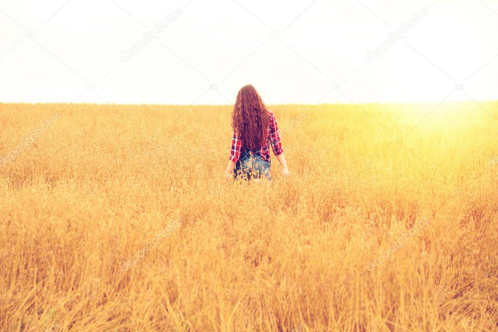 Young beautiful woman walking in a field, summer outdoors