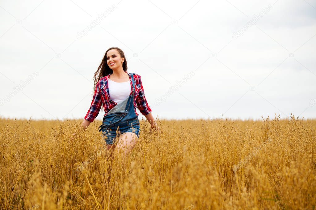 Young beautiful woman walking in a field, summer outdoors