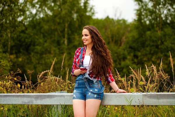 Young beautiful brown haired woman in blue jeans — Stock Photo, Image