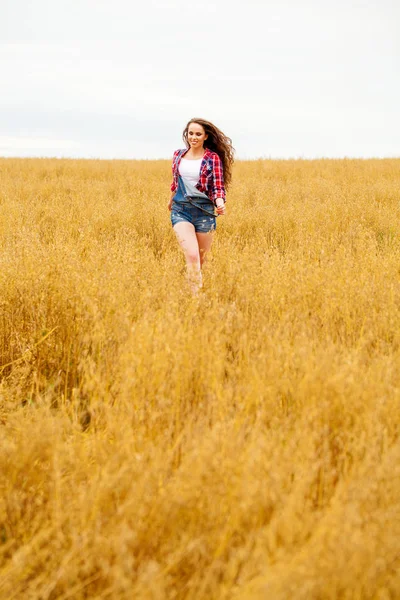 Jovem mulher bonita andando em um campo, verão ao ar livre — Fotografia de Stock