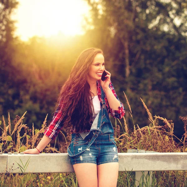 Junge schöne braunhaarige Frau in blauen Jeans — Stockfoto