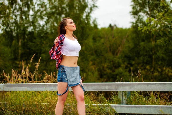 Jovem bela mulher de cabelos castanhos em jeans azuis — Fotografia de Stock