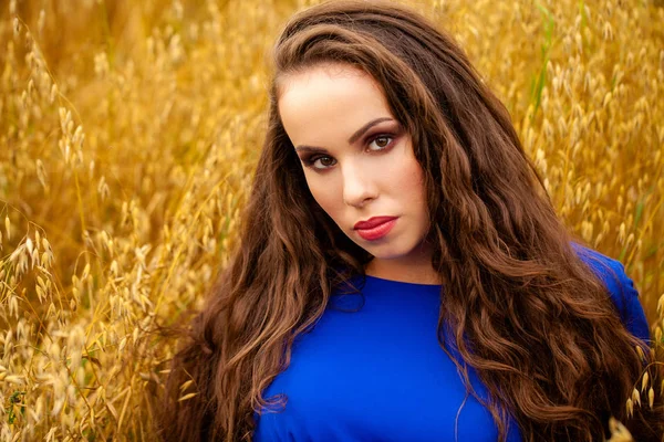 Retrato de uma jovem em um fundo de campo de trigo dourado — Fotografia de Stock
