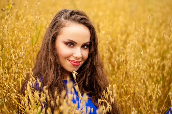 Retrato de uma jovem em um fundo de campo de trigo dourado — Fotografia de Stock