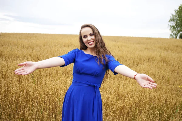 Retrato de uma jovem em um fundo de campo de trigo dourado — Fotografia de Stock
