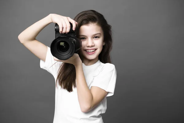 Menina morena bonito segurando uma câmera de fotos — Fotografia de Stock