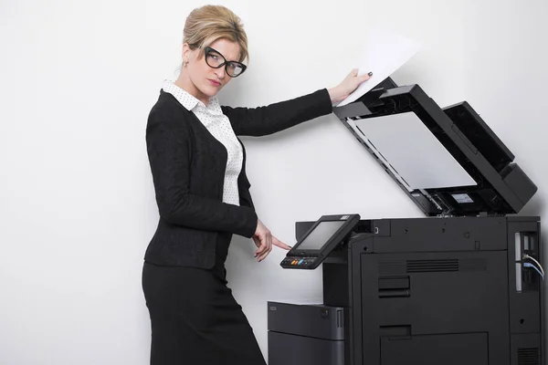 Ung smuk kvinde laver kopier på kontoret - Stock-foto