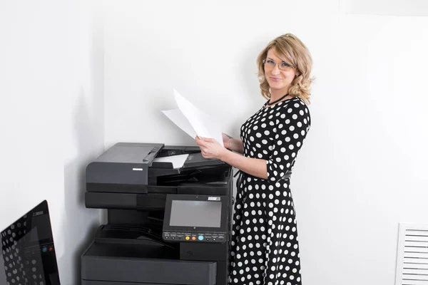 Jovem bela mulher fazendo cópias no escritório — Fotografia de Stock