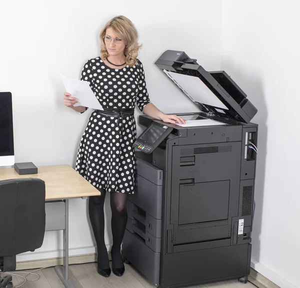 Young beautiful woman making copies in the office — Stock Photo, Image