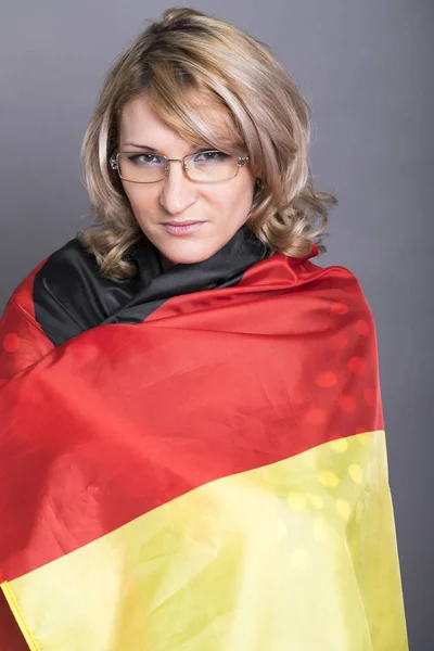 Schöne Frau in die deutsche Fahne gehüllt — Stockfoto