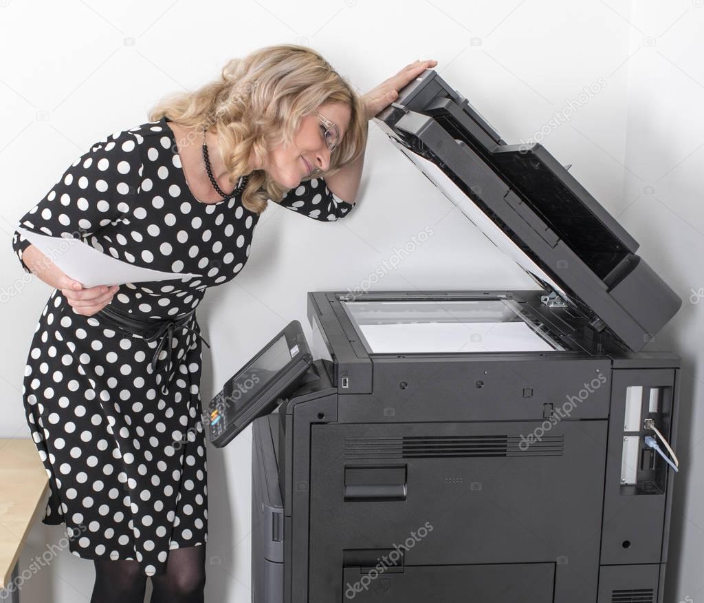 Young beautiful woman making copies in the office