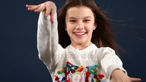 Красива маленька дівчинка з руками на повітрі ізольований синій фон — стокове відео