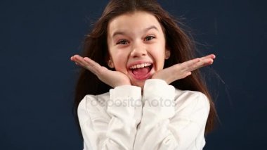 Mutlu küçük kız kapatır ve onun yüzüne, izole mavi arka plan ellerini açar