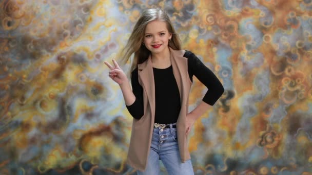 Hälsningen. Vacker blond liten flicka poserar i studio — Stockvideo