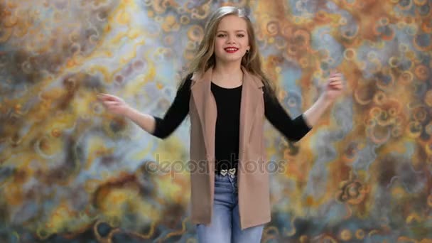 Hälsningen. Glad liten tjej poserar i studio — Stockvideo