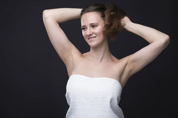 Mulher morena em uma toalha branca com as mãos para cima — Fotografia de Stock