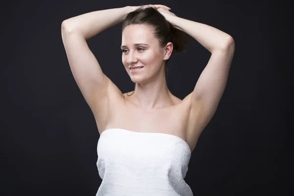 Bruna donna in un asciugamano bianco con le mani in alto — Foto Stock