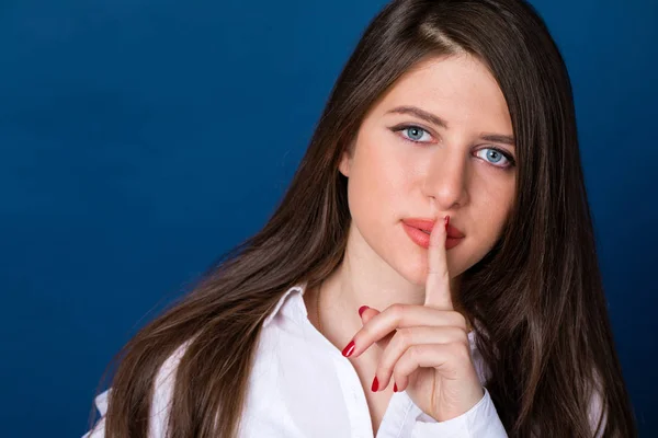 Beautiful brunette woman has put forefinger to lips as sign of s — Stock Photo, Image