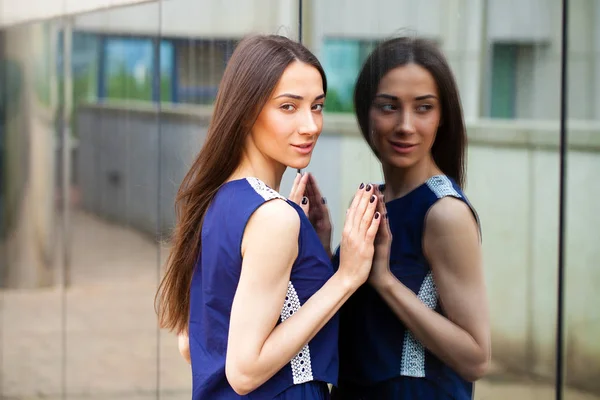 Stylish lady in blue dress posing near mirrored wall — Stock Photo, Image