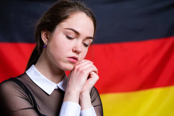Beautiful calm brunette girl in the background of the German fla — Stock Photo, Image