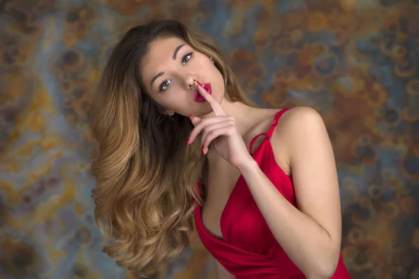 Молодая красивая женщина положила указательный палец в губы в знак силе — стоковое фото