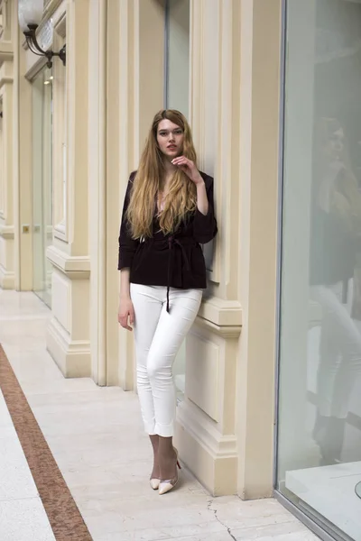 Beautiful blonde woman in white pants and corduroy jacket