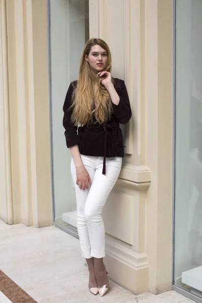 Beautiful blonde woman in white pants and corduroy jacket