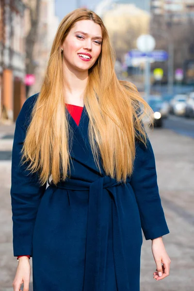 Portrait of a young beautiful woman in blue coat — Stock Photo, Image